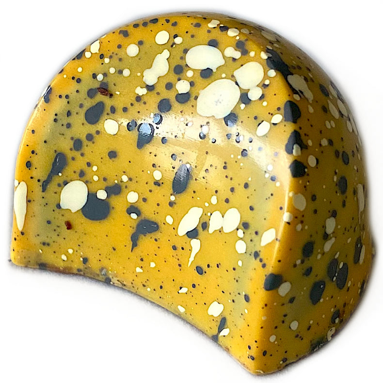 A fun twist on some favorite flavors, this dark chocolate shell contains a bright and fruity passion fruit ganache, topped with a nutty black sesame sauce for a rich finish